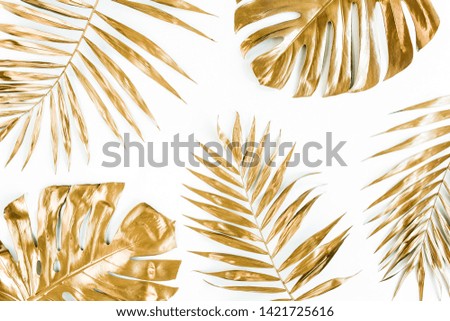 Gold tropical palm leaves Monstera on white background. Flat lay, top view minimal concept.