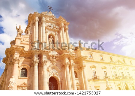 Beautiful Roman Catholic Cathedral of Syracuse in Sicily, Italy taken from below in orange sunset light. The temple is part of UNESCO World Heritage. Baroque architecture. Popular tourist spot.