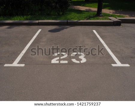 Numbered marking on the asphalted parking place for the car, painted with white paint. 