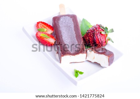 Ice cream in chocolate icing on stick with strawberries and mint. Studio Photo