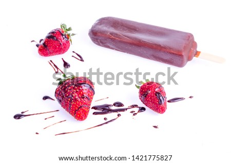 Ice cream in chocolate icing on stick with strawberries and mint. Studio Photo