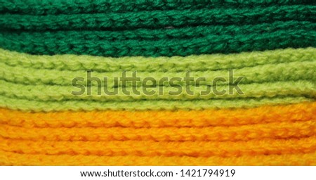 A pile of bright green and yellow knitted elements. Warm and soft background, wallpaper, pattern