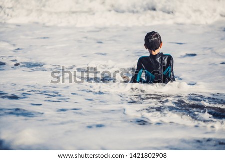 A beginners surf lesson of two young kids having fun in a sunny day in summer in the Mediterranean Sea