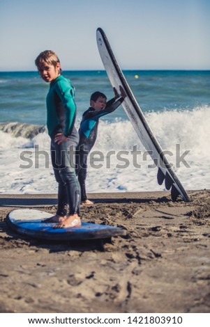 Active Young boys in a funny surfing day in the summer time