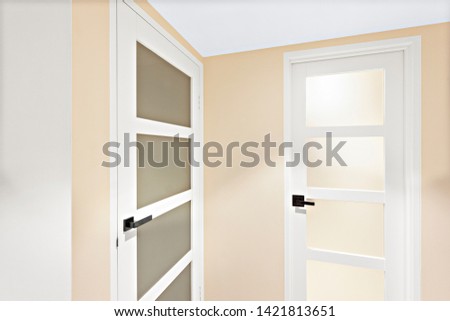 Two simple doors with sleek handles and opaque glass