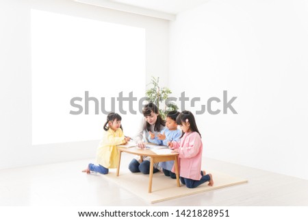 Children and teacher painting at preschool