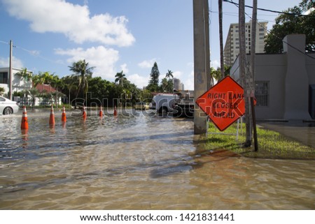 A 'Right lane Closed' sign in flooded Las Olas Blvd in Fort Lauderdale, FL.