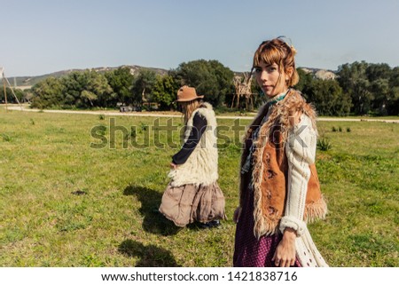 Two Boho Style Woman In a romantic country side walk in a sunny day