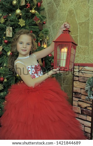 girl in a red dress with a flashlight. on Christmas