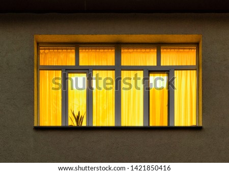 night in city with yellow light inside big house window Royalty-Free Stock Photo #1421850416