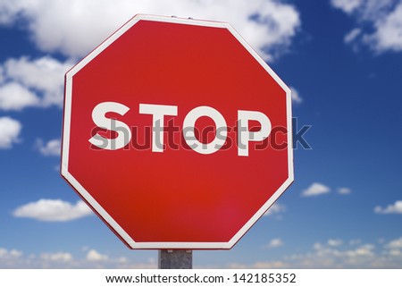 Stop sign and blue sky with white clouds