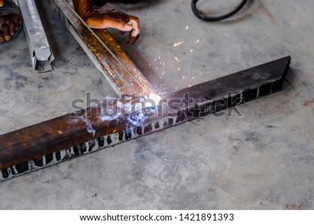 The mechanic was using a tool to weld iron until it sparked
