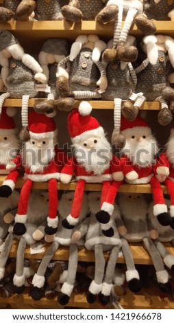 Cute Santa Claus dolls that are in the doll shop window.