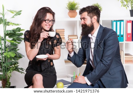 Office rumors. Couple coworkers relax coffee break. Share coffee with with colleague. Flirting colleagues. Bearded man and attractive woman. Man and woman conversation coffee time. Office coffee.