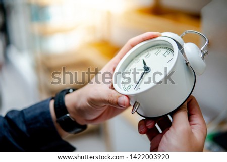 Male hand adjusting or changing the time on white clock. Time management concept. Royalty-Free Stock Photo #1422003920