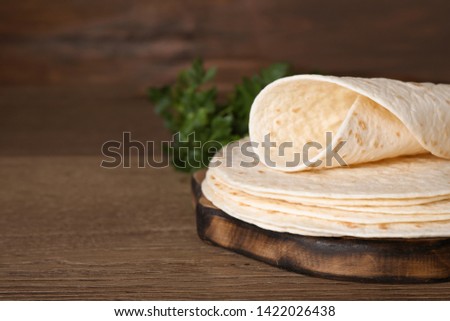 Wooden board with corn tortillas on table, space for text. Unleavened bread