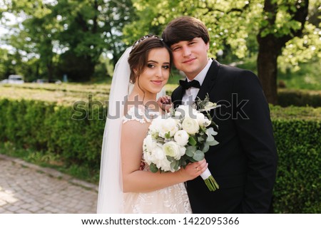 Happy groom and bride walking in the park. Charming woman with handsome man spend time together