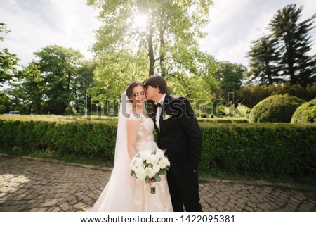 Happy groom and bride walking in the park. Charming woman with handsome man spend time together