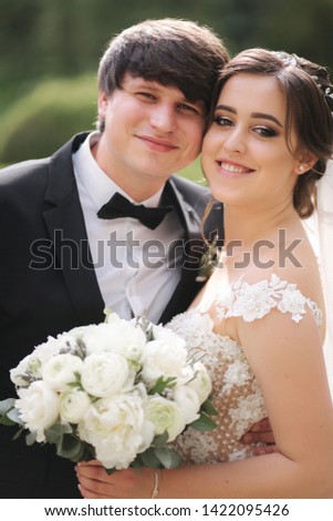 Close-up portrait of beautiful wedding couple. Handsome groom with gorgeous bride
