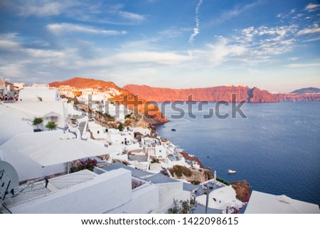 beautiful Oia town on Santorini island, Greece. Traditional white architecture and greek orthodox churches with blue domes over the Caldera, Aegean sea, Scenic travel background