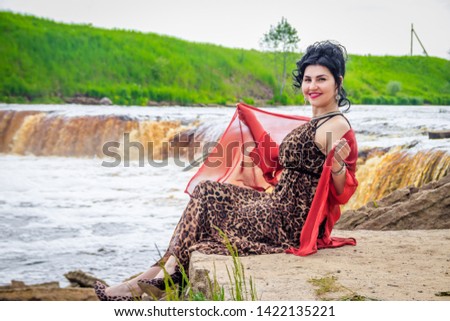 Woman on the waterfalls. Little waterfall. Camping. . Young woman. Woman in a dress.
