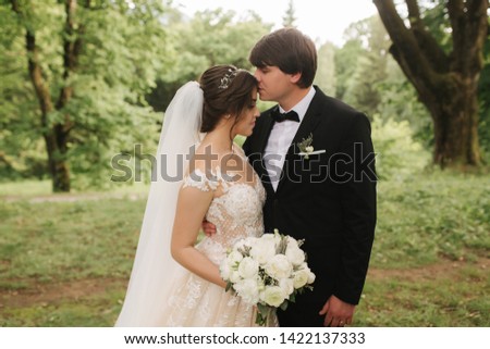 Just married couple on green background, broom and bride walking in the forest