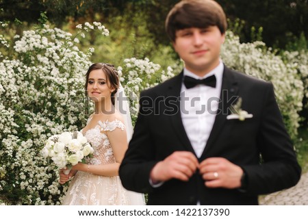 Handsome groom staind in front of beutiful bride
