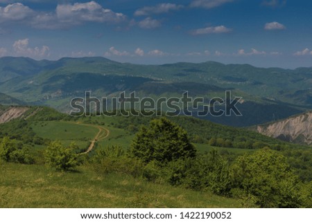 Mountain landscape on a summer day.
Green mountains with trees and sky with white clouds.