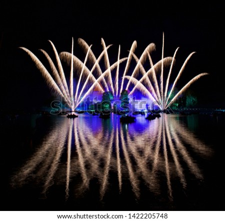 Fireworks in Trakai, Lithuania. Big colorful fireworks explode with nice reflection on a water, July, Independence, fireworks with old castle in the background.Trakai Castle near the lake. Lithuania.