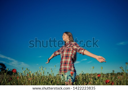 Beautiful girl in poppy field. girl in summer,. Young girl with long hair among the blossoming poppy field. concept of freedom and travel. Poppy buds. Gardening