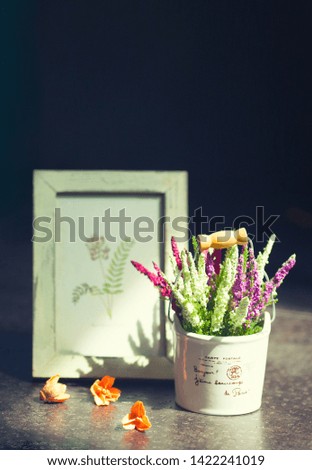 Provence style flower pot in pastel colors with bokeh background. Sign on the pot translation: "Post card. Hello beautiful Paris."
