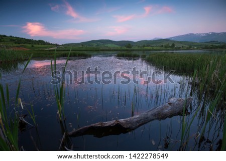 Magical Sunset Over the Mountains lake. Colorful sky under sunlit reflected in water. Awesome alpine highlands in sunny day. Picture of wild area. Wonderful Natural Background, view with Dramatic sky.