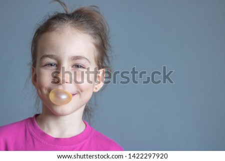 Funny girl inflates a big ball of chewing gum