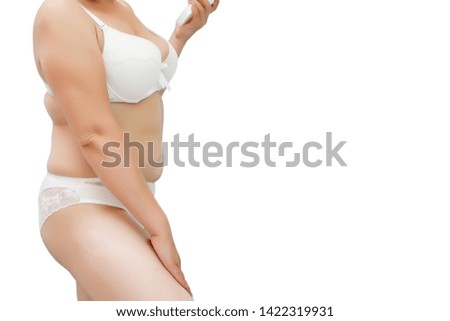 a woman with excess weight applying cream on the hips