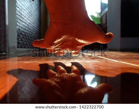 Hand and shadow of the hand from the light on the floor