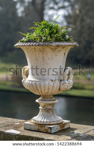 Victorian White Ceramic Garden Plant Pot with handles full of green plants.