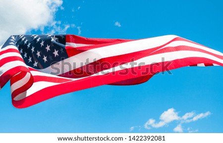  American flag in blue sky background. United States holiday
