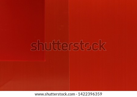 Corner of a Red Square on a Glass Partition in Front of Red Wallpaper Background in an Office