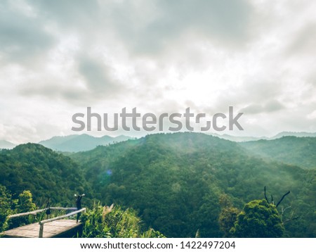 travel in tropical forest and camping, adventure vacations concept from woman photographer is taking picture of sunset mountains landscape with happiness and freshness.