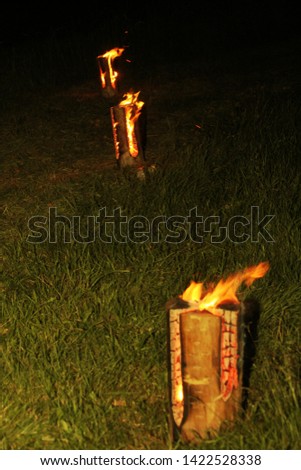 Wood block burns with fire in the meadow. Old Latvian culture tradition. Midsummer night celebrating in Latvia. Celebration of "Ligo" feast