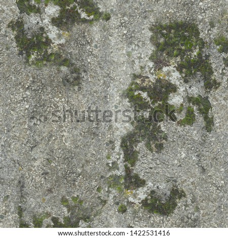 The wall of stone has aged with time and sprouted green moss.Texture or background