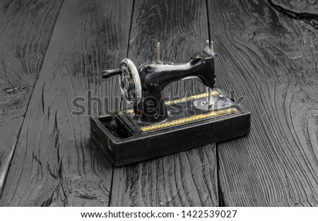 black vintage sewing machine on a black wooden table