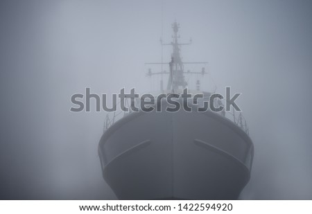Ghost ship. Warship in the fog or mist as a flying Dutchman. Gray color. Mystery concept. Pirate Code, doomed vessel rise from the sea, spreading terror across the ocean lore. phantom ship doomed Royalty-Free Stock Photo #1422594920
