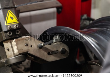 The process of repairing an automobile wheel using a special press on a machine for straightening disks for vehicles after damage in a pit on the road in the workshop. Auto service industry.