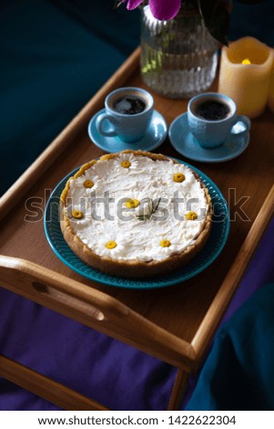 Top view - breakfast in bed a delicious cheesecake and two cups of coffee are on a wooden tray