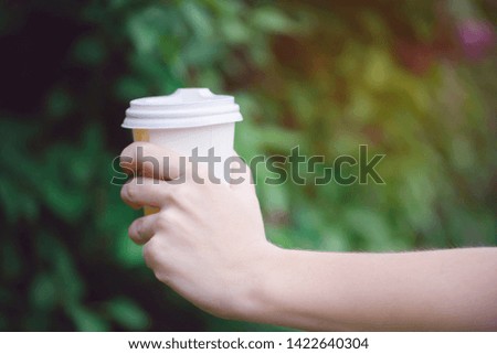 Beautiful hand with a stock of aromatic coffee in a beautiful park
