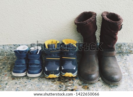 three pairs of winter shoes of mom and kids. Family activity concept.