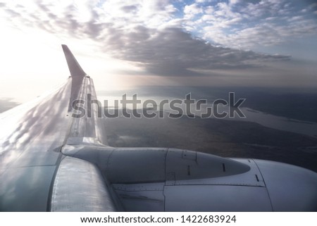 View from the airplane window on the river below. Tourist route to warm countries. The theme of the travel agency. Stock photo