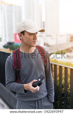 Half length of young  man outdoor in the city holding instant vintage camera, shooting - photography, creative, artist concept 