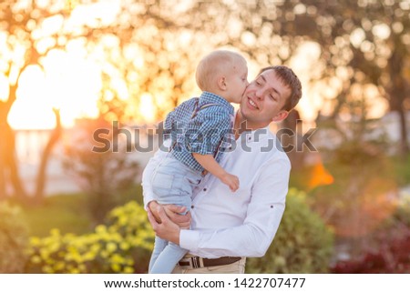 Happy young father having fun with her child in summer sunny day. Family lifestyle, paternity, love and tender moments concept